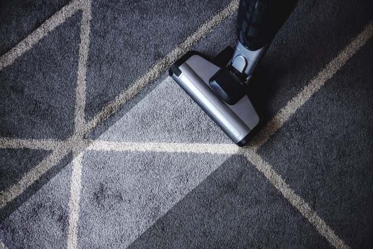 Aspirateur professionnel sur un tapis gris à motifs géométriques