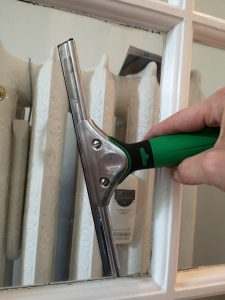 Raclette professionnelle essuyant une vitre de fenêtre